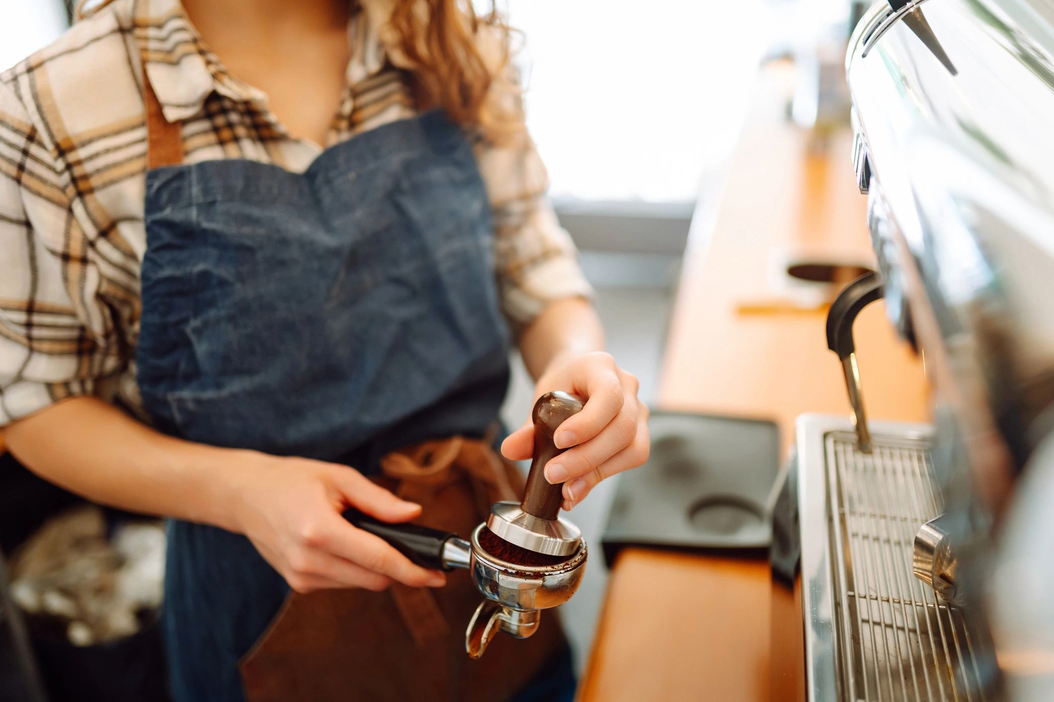 Barista preparing a fresh coffee behind the counter