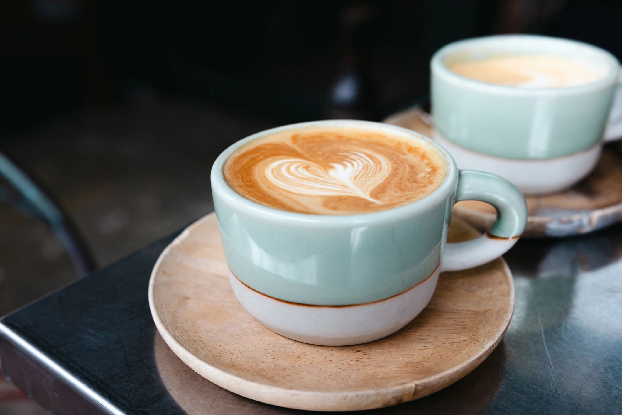 Latte art and coffee beans on a café table